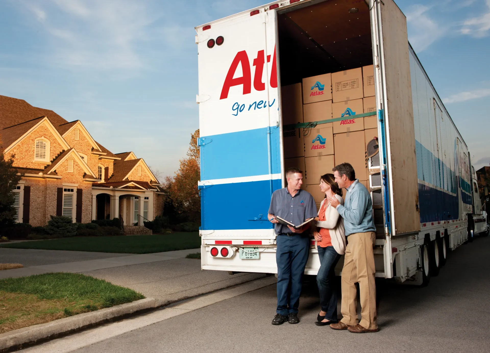 people standing beside an atlas moving truck